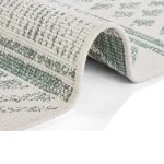 The Carpet has a cream colored base with a subtle repeating pattern in a light gray or blue color