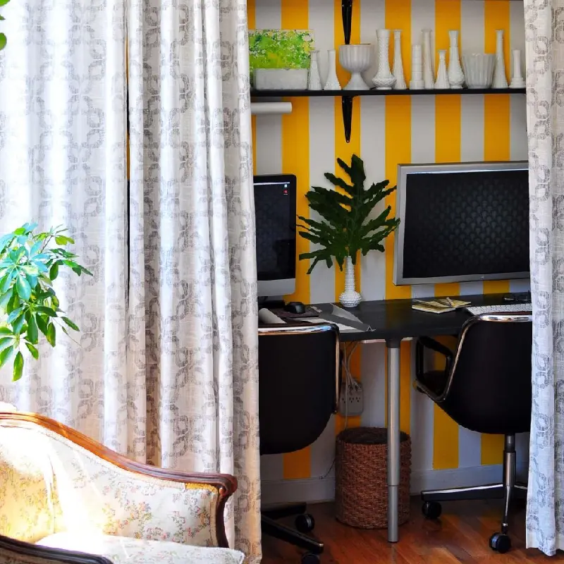 curtains create a cozy and private workspace within a larger room, highlighting a vibrant yellow accent wall